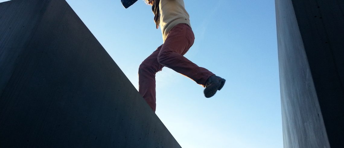 A man jumping between a gap on a roof